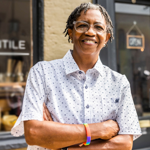 old woman with arms crossed smiling