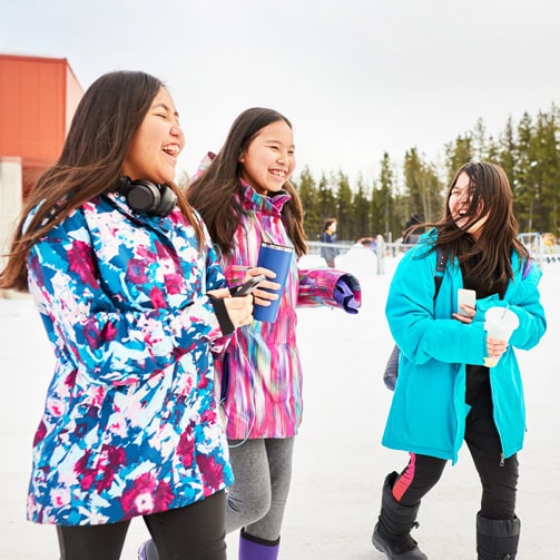 three women playing on the snow