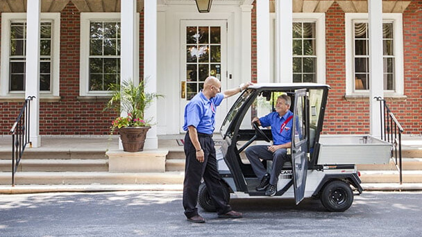 a worker talking with another one on a car