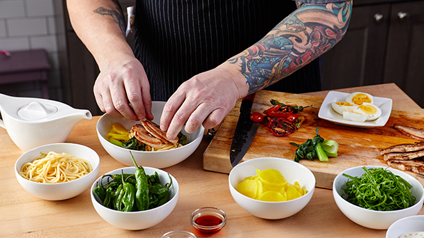 person preparing food with ingredients ready on table