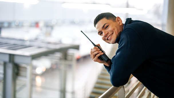 man smiling and talking by a radio