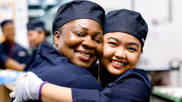 women in uniform hugging each other