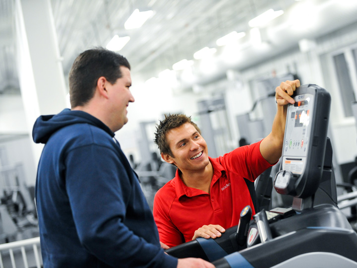 personal trainer showing something to a man in a gym