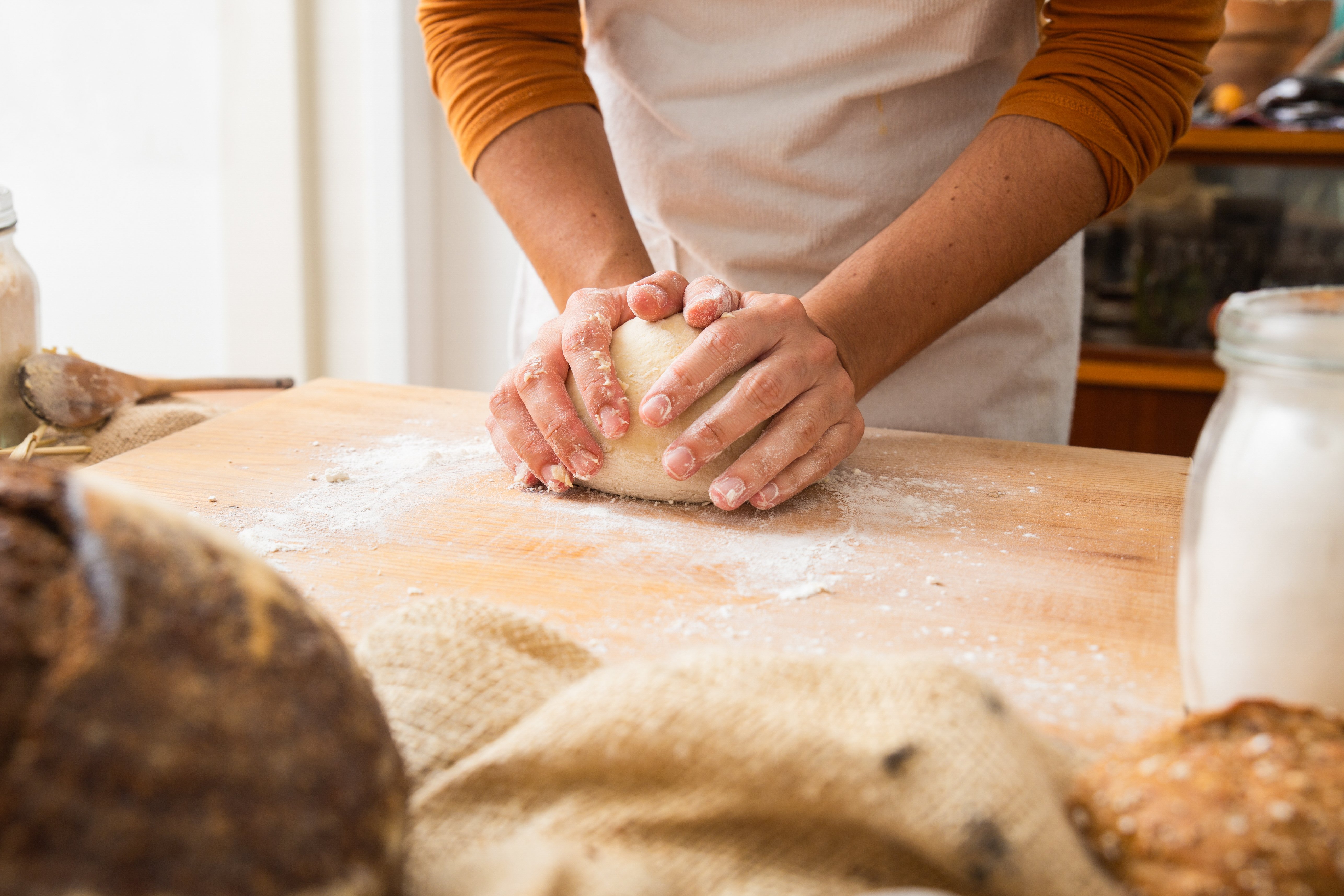 baker-forming-dough-sphere-wooden-board