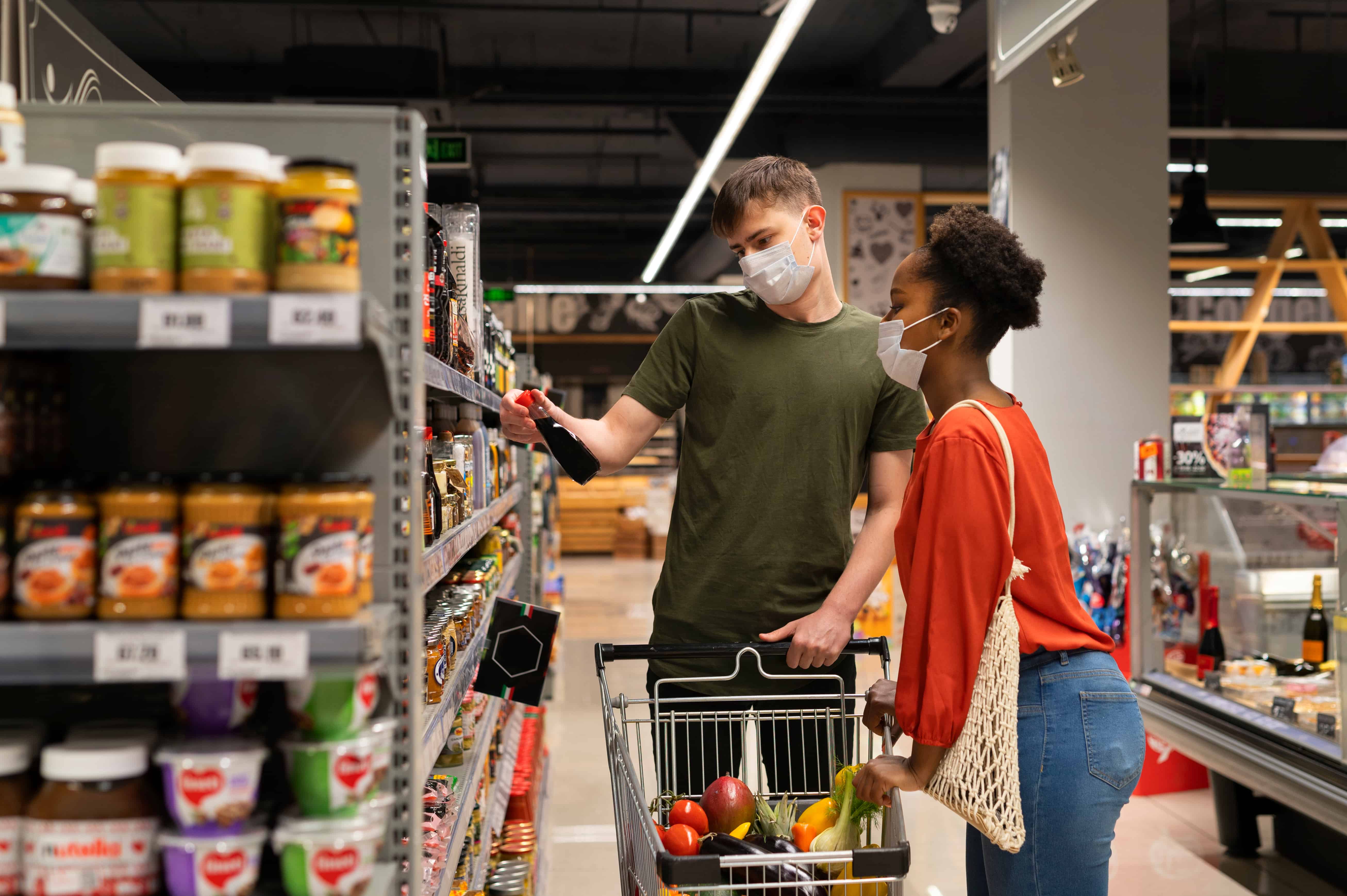 man-woman-with-medical-masks-out-grocery-shopping-with-shopping-cart (1)