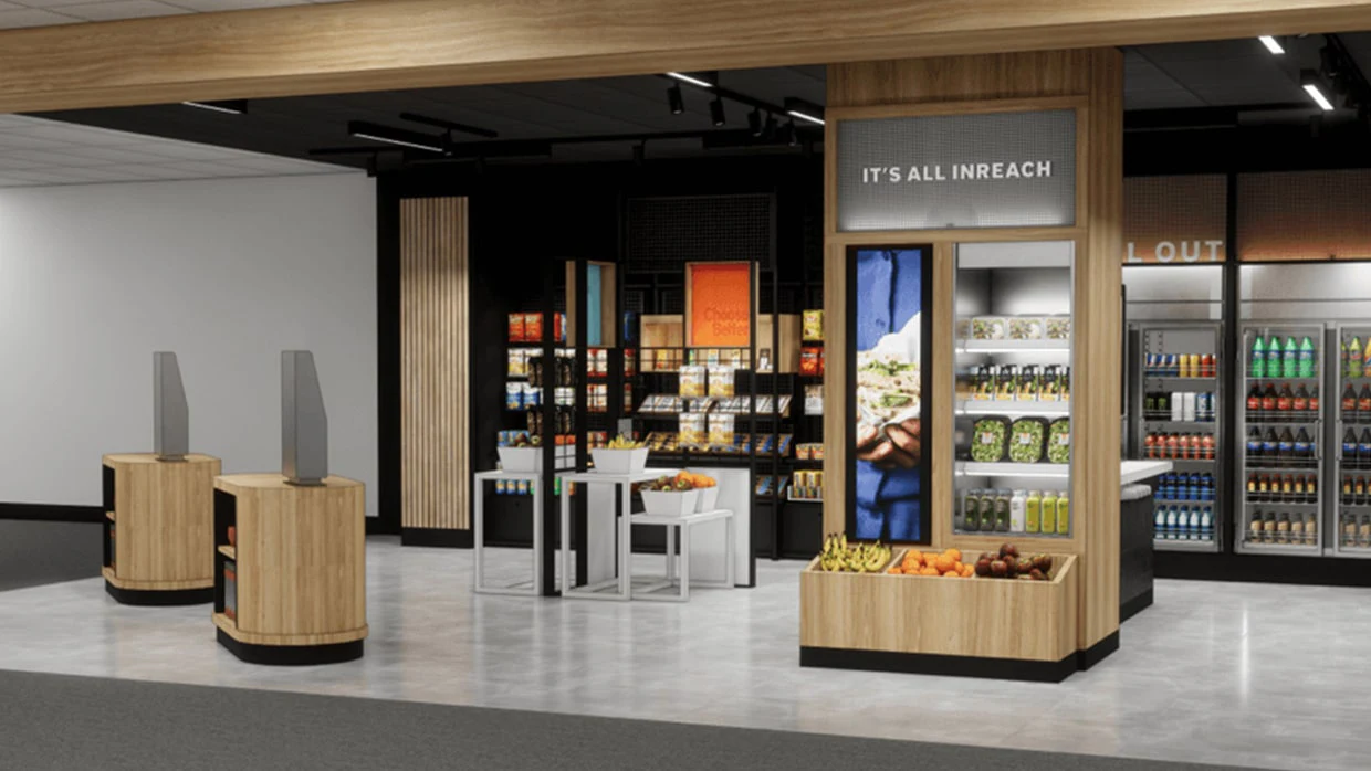 Modern store interior with wooden fixtures, shelves of packaged goods, fresh produce displays, and refrigerated drinks.