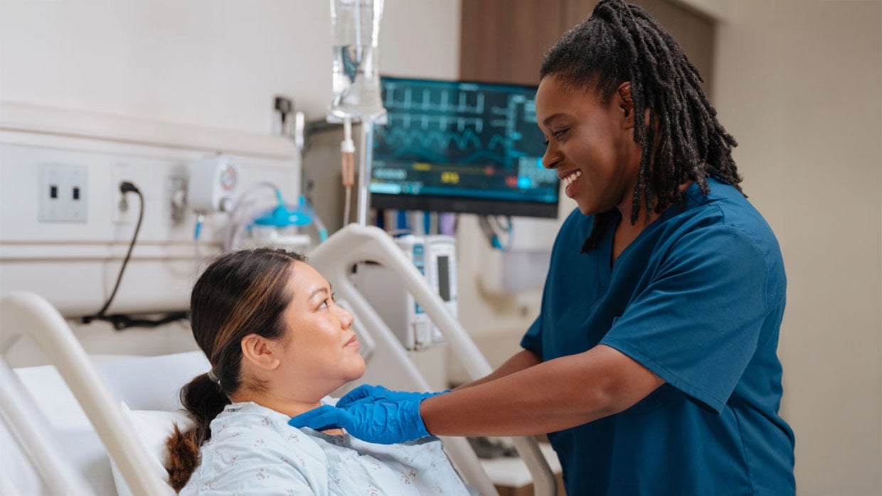 A Registered Dietitian Nutritionist performing a bedside swallow evaluation on a patient.