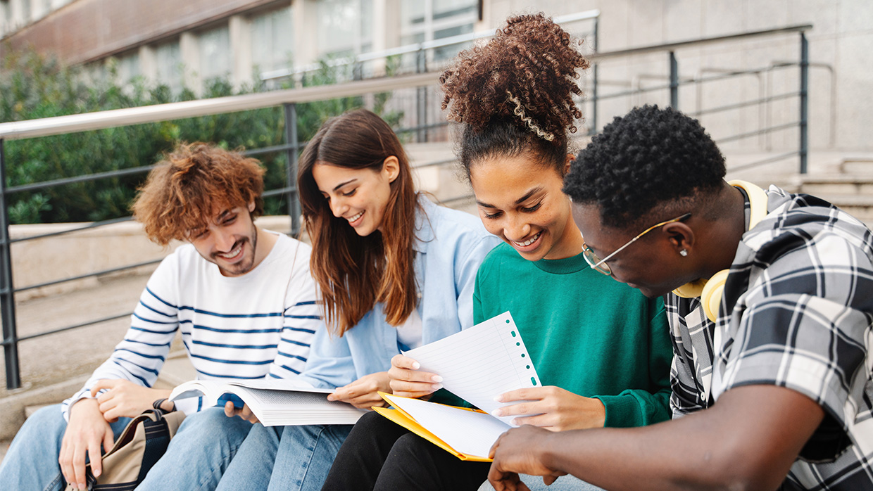College students sitting on outdoor campus steps, working together