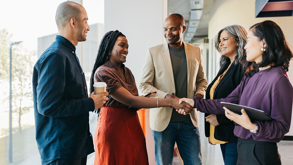 A diverse group of individuals having a friendly conversation in a hallway