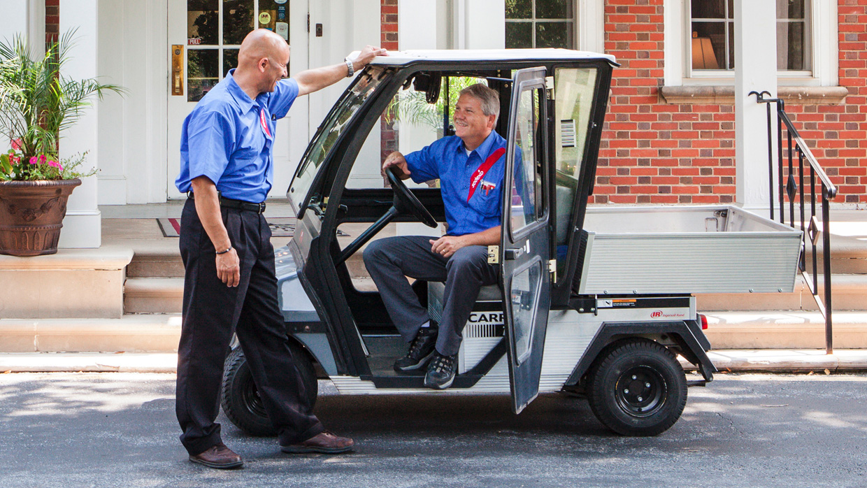 a man in a car speaking with another man