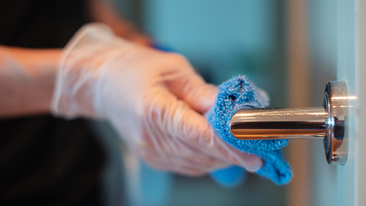 cleaning staff cleaning a door handle