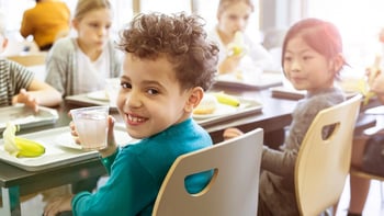 Elementary students eating together in school lunchroom.