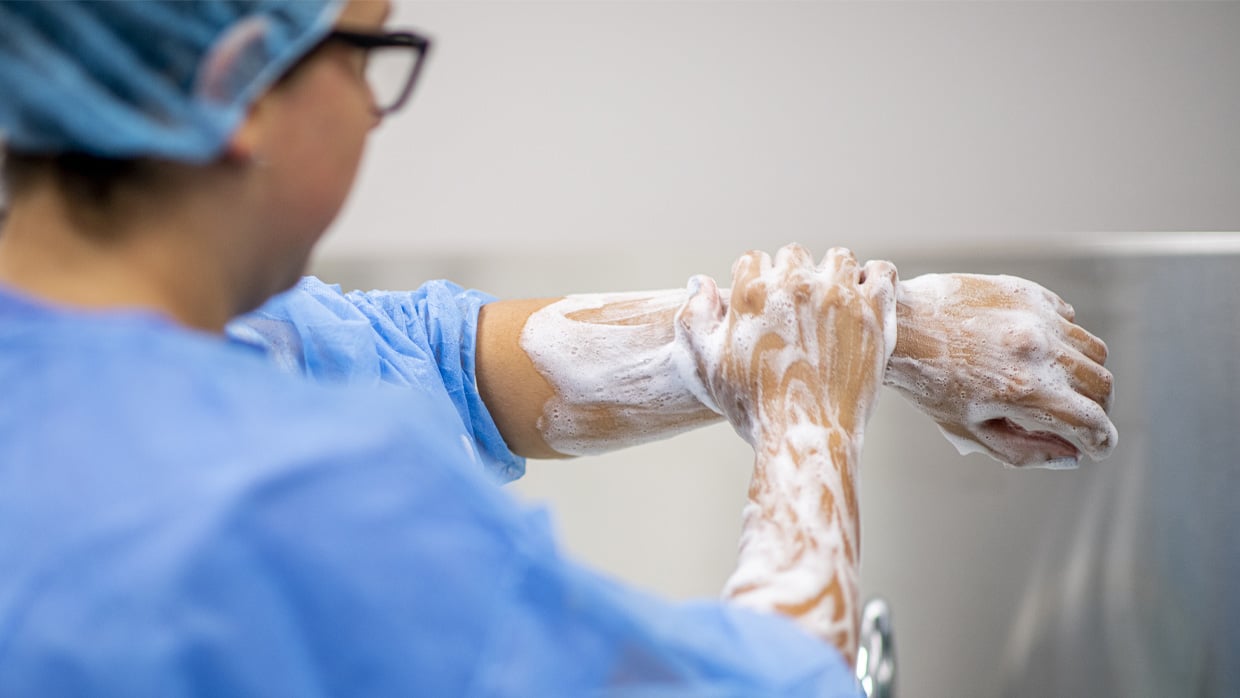 Female healthcare worker washing hands to ensure proper hand hygiene