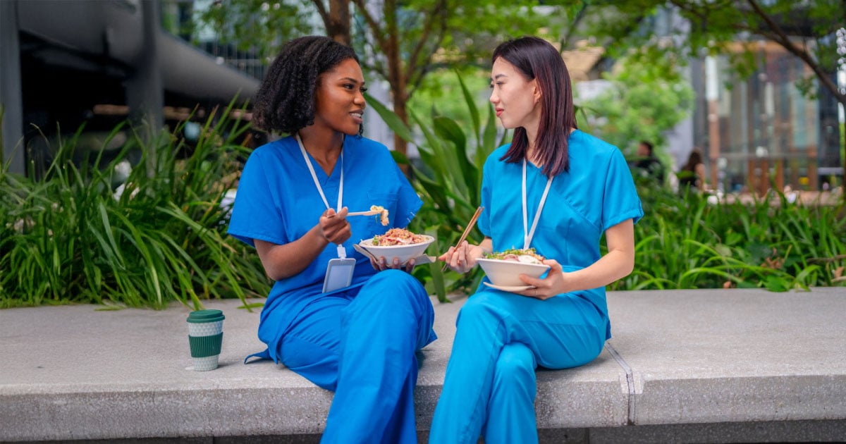 Two healthcare employees enjoying a peaceful outdoor lunch break together