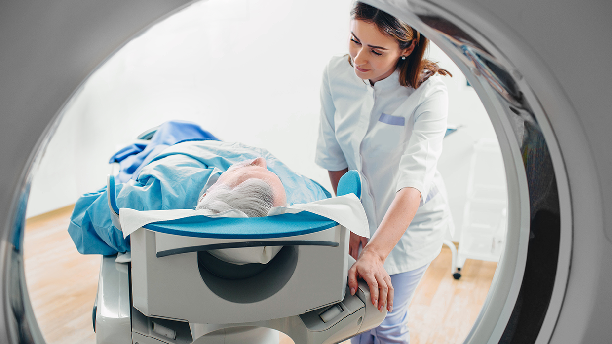 female staff with patient in ct scan