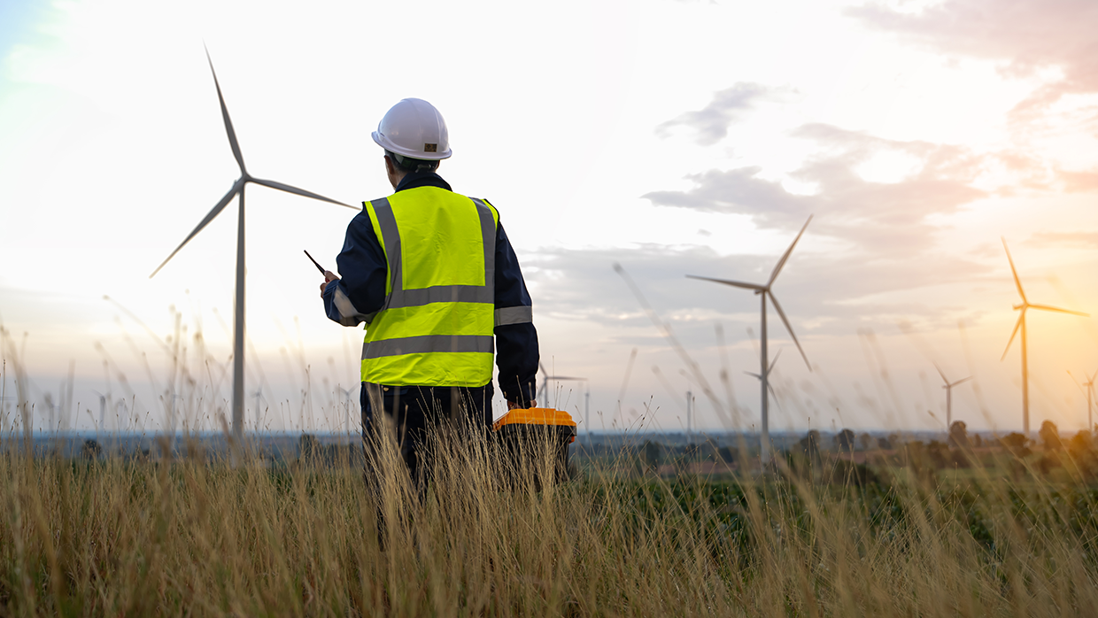 man in a field and windmill