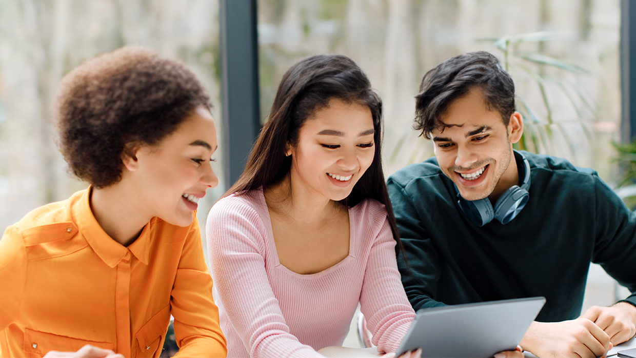 young people looking at tablet device having fun