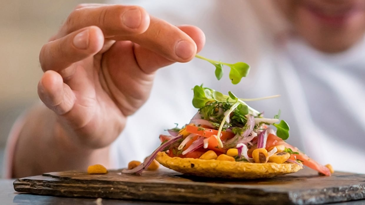 chef adding the finishing touch to a plate of food