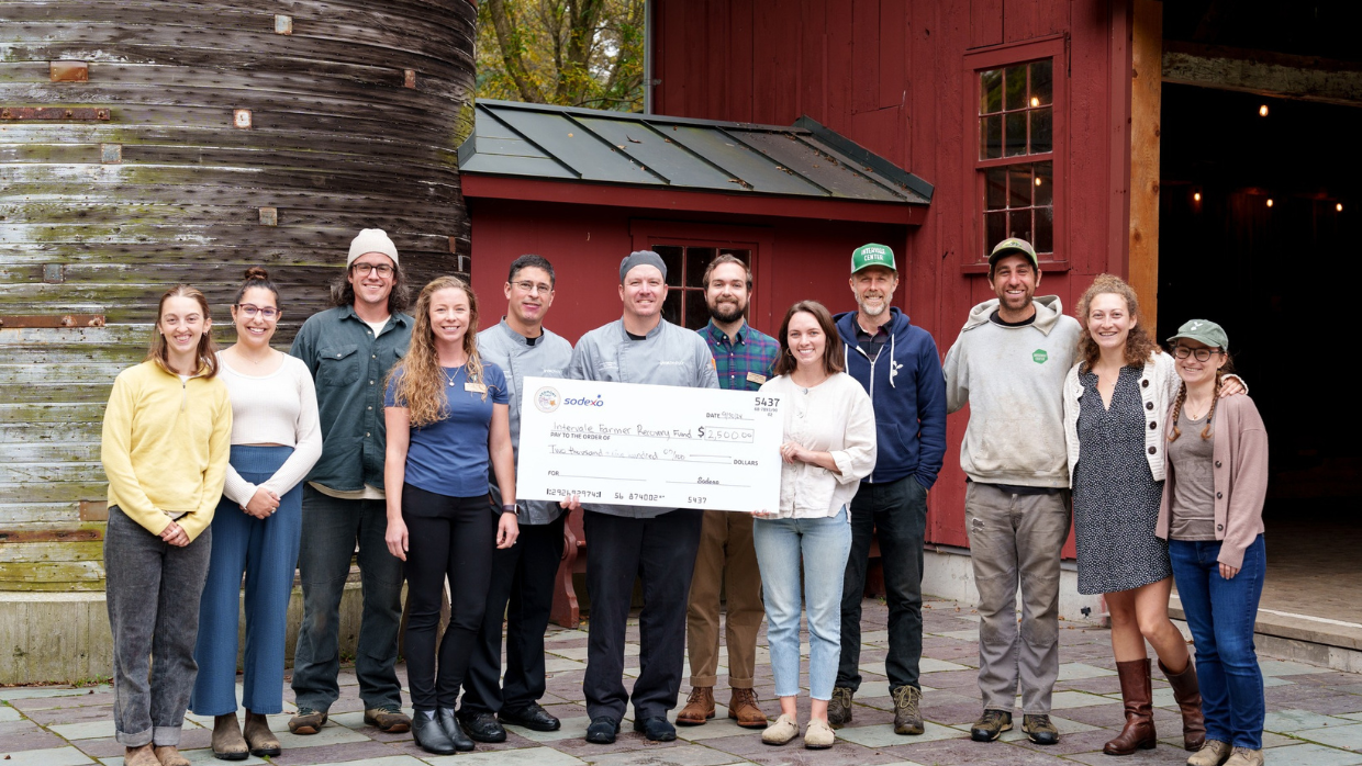 Group photo of Sodexo, UVM, and Intervale representatives holding a $2,500 check for the Intervale Farmer Recovery Fund.