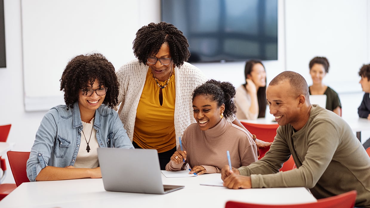 Professor engaging with a group of students in a university classroom