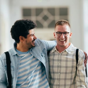 Two college students sharing a laugh while walking on campus.
