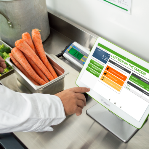 person weighing carrots with the help of an application