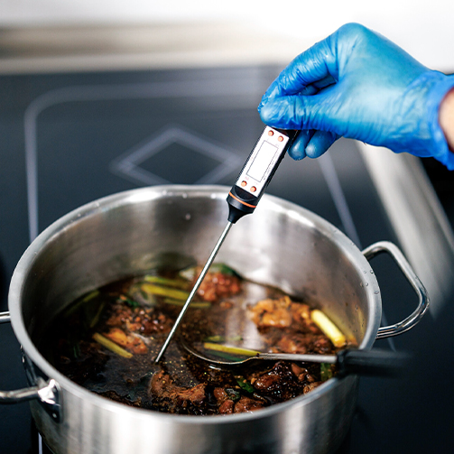 someone testing the food temperature 