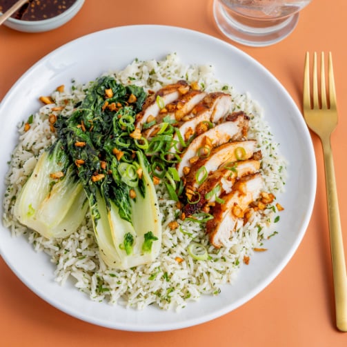 Plated dish featuring chicken, steamed rice and bok choy.