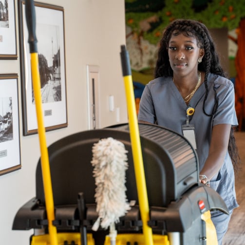 Service attendant pushing a cleaning cart.