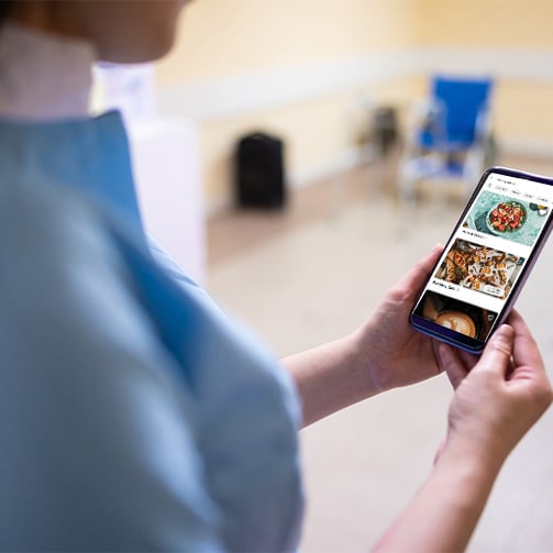 Nurse using a mobile phone to place a food order. 