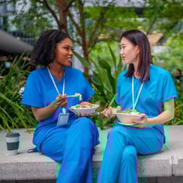 Two healthcare employees enjoying a peaceful outdoor lunch break together