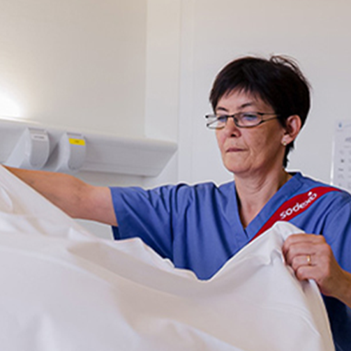 female staff making bed at hospital