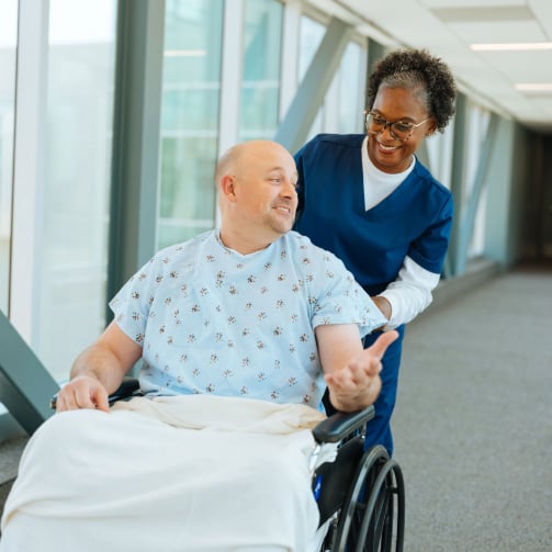 Healthcare staff assisting a patient in a wheelchair