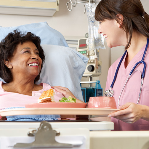 Young female doctor visiting patient hospital room