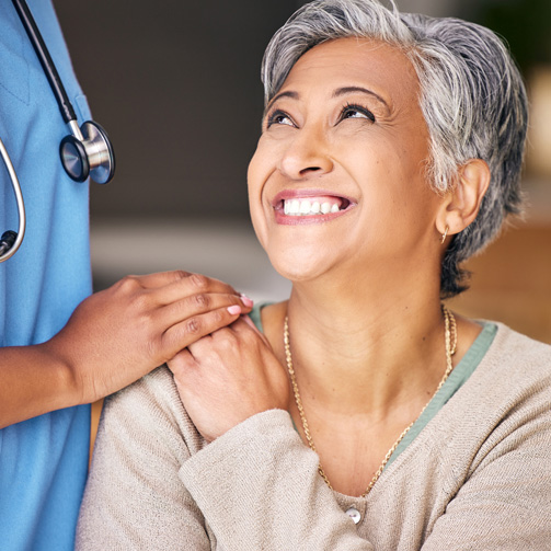 Middle age woman smiling next to a doctor