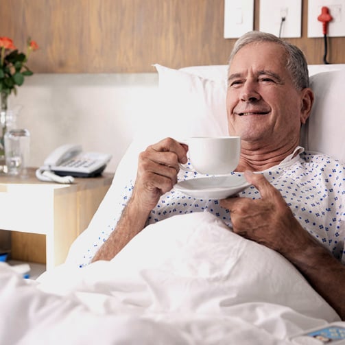 man in a hospital bed smiling