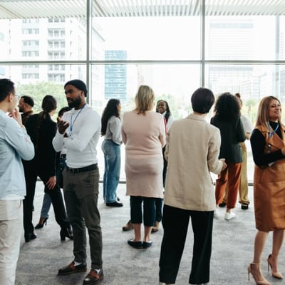 A diverse group of professionals networking during an industry event in a contemporary office setting.