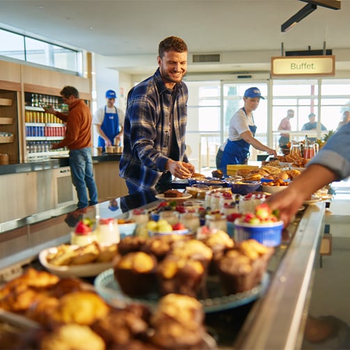 A man making a plate at a buffet style breakfast arrangement