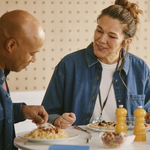 A man and women enjoying a meal in an inviting setting