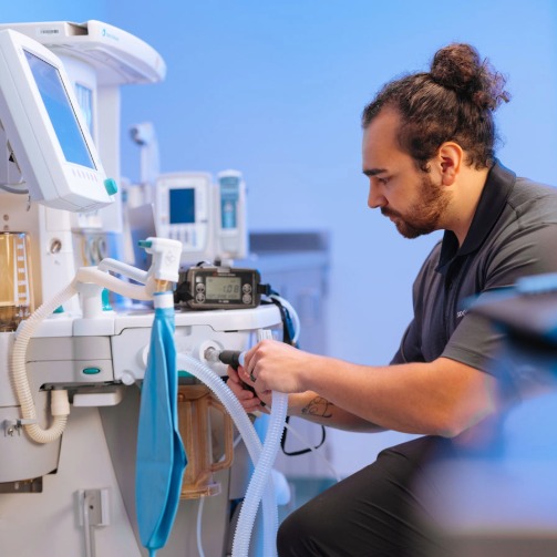 Technician inspecting and servicing medical equipment.