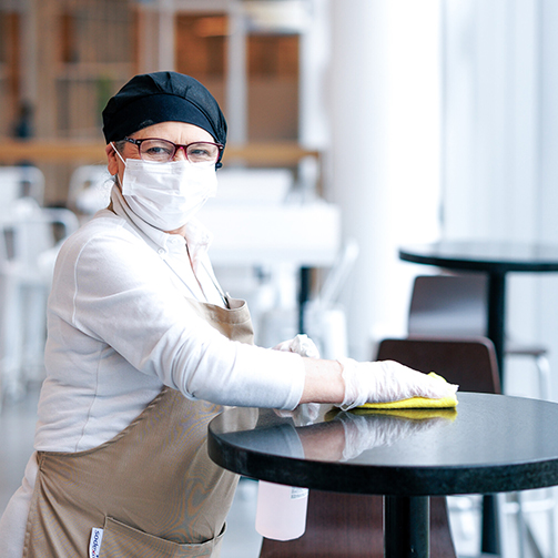 woman cleaning a table