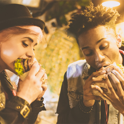 Two college students enjoying burgers together.