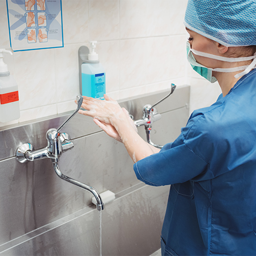A surgeon washing her hands thoroughly.