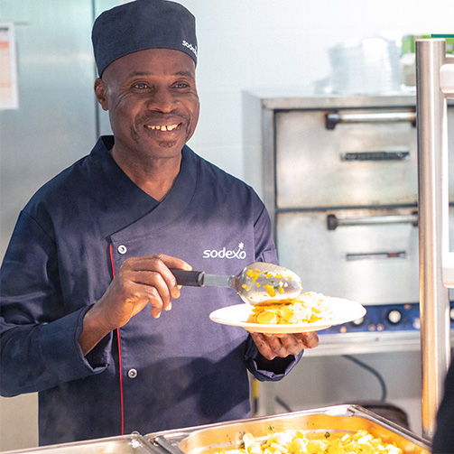 a man making a food and smiling