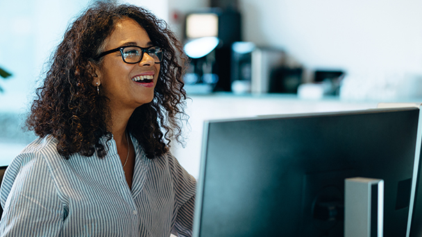 a woman smiling in front of a computer