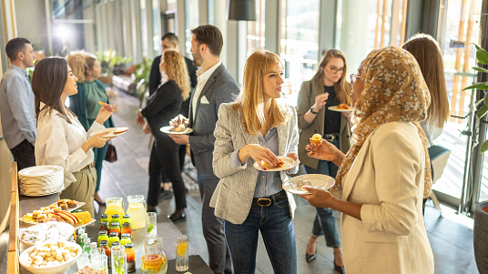 People networking and eating snacks at a conference gathering.
