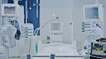 ICU hospital room with connected medical devices and network security overlay, illustrating healthcare cybersecurity risks.