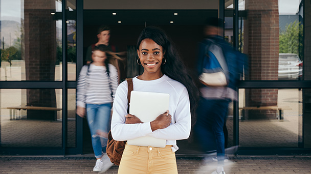 a girl smiling and holding a book