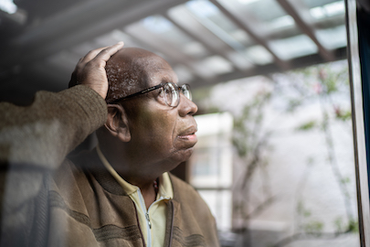 old man looking a window with their hand on head