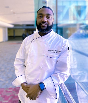 Black men smiling with chef uniform.
